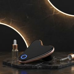 Smart electric Gua Sha scraping massager with LED indicator on dark moody background with gold accent lighting